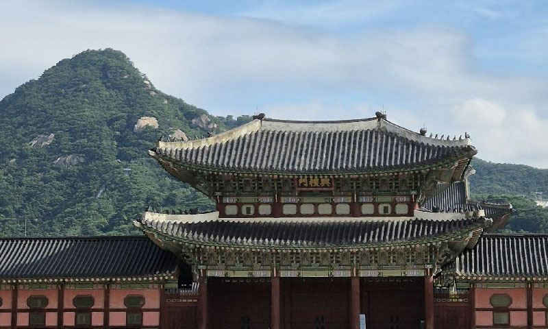 Gyeongbok Palace in Seoul, Korea with a mountain in the background.